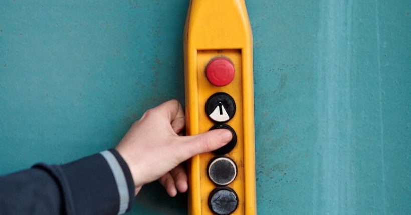 a hand clicking the buttons of the control panel