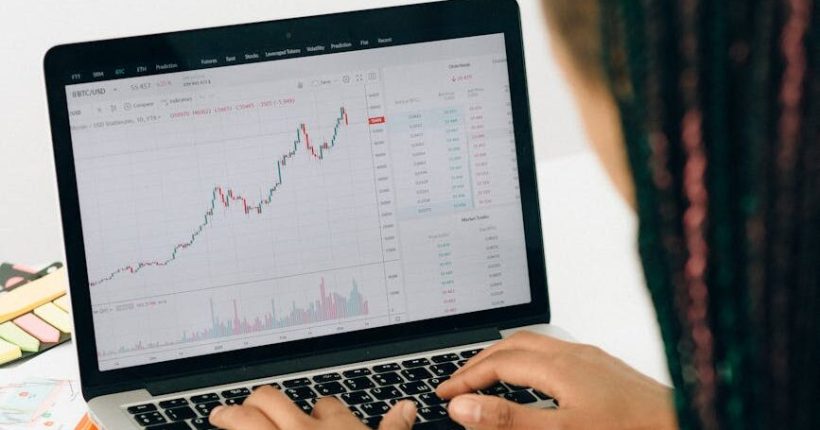 person using macbook pro on white table