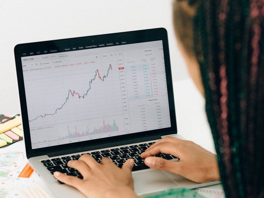 person using macbook pro on white table
