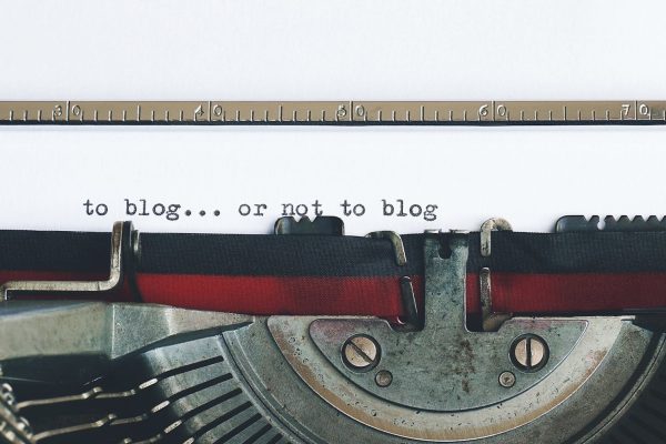 Classic typewriter with 'to blog or not to blog' typed on paper.