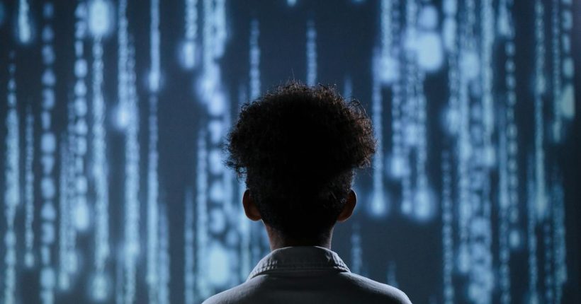 A young boy viewing a digital screen with data streams, symbolizing technology interaction.