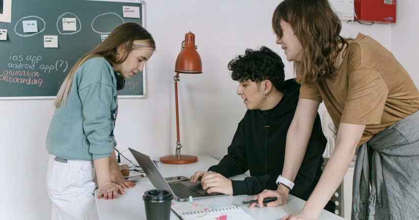 Group of young developers brainstorming ideas for a tech startup in a modern office setting.