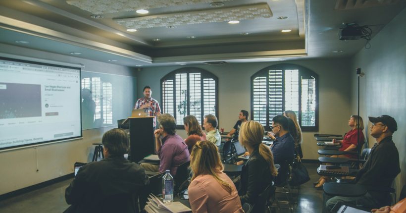 a group of people in a room with a projector screen