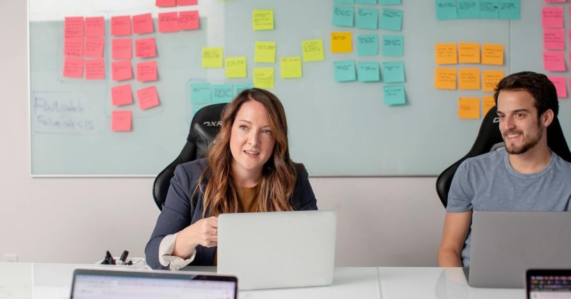 Two colleagues in a modern office environment brainstorming and planning business strategies.