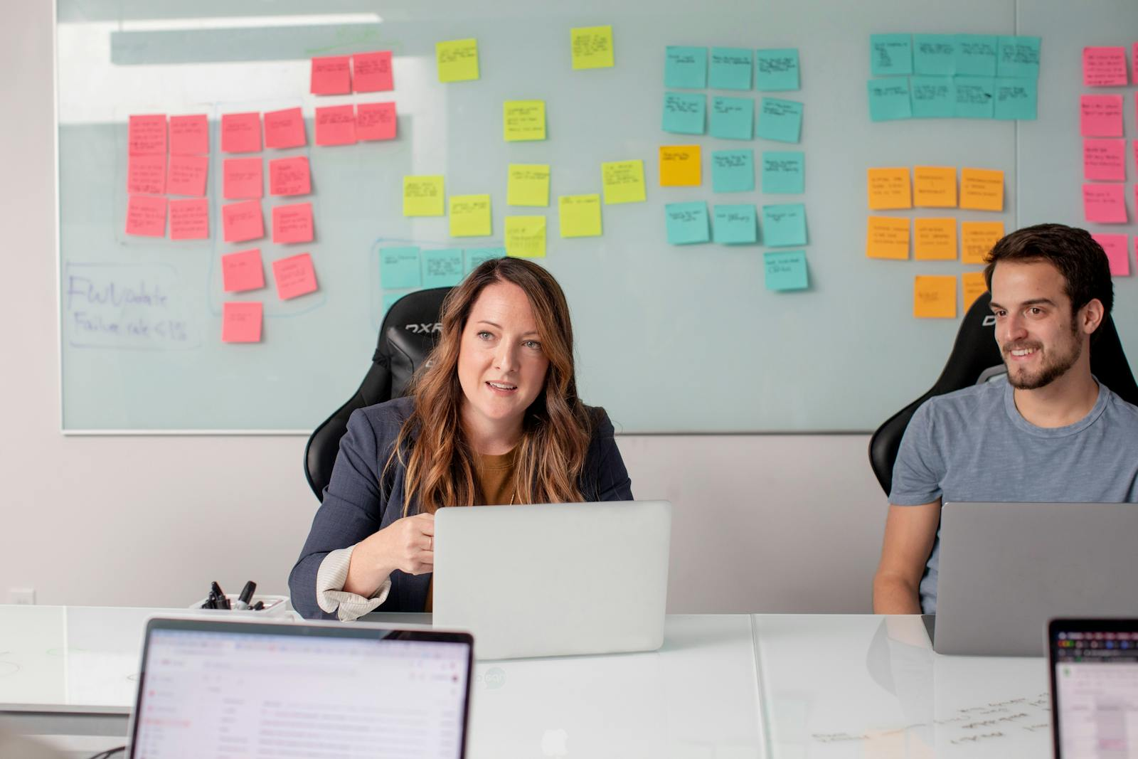 Two colleagues in a modern office environment brainstorming and planning business strategies.