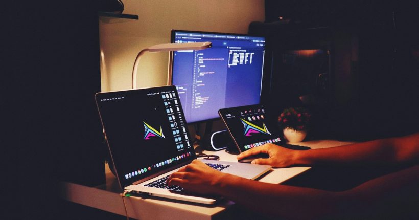 woman in black tank top sitting in front of computer