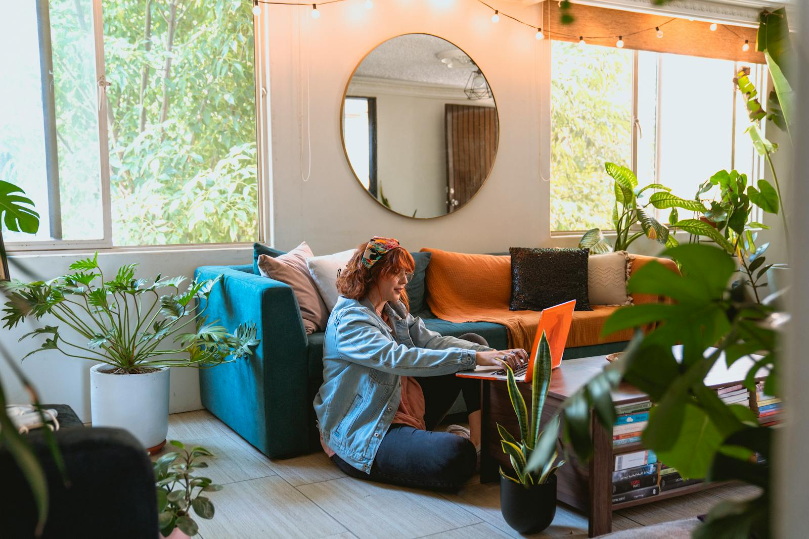 Woman working remotely from a cozy living room surrounded by plants.