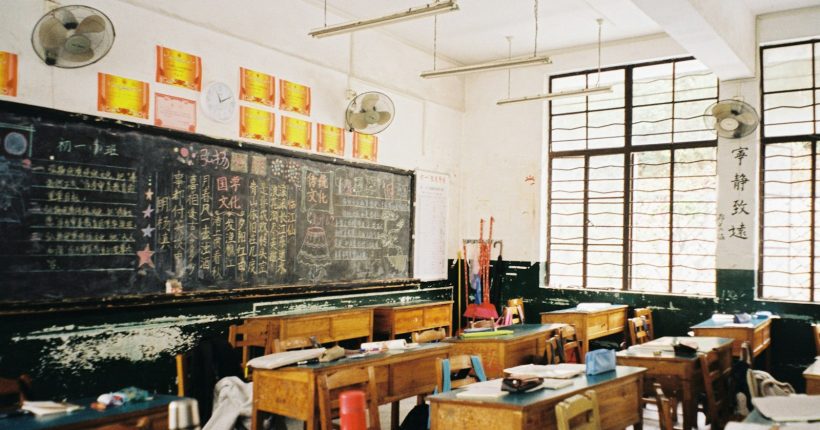 a classroom filled with desks and a chalkboard