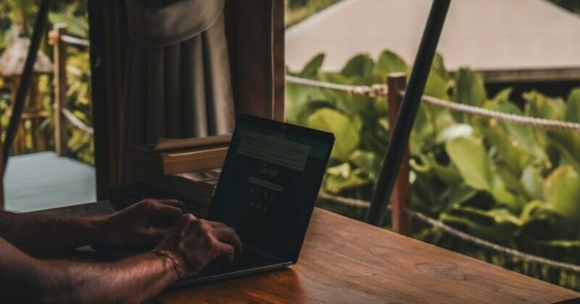 A man sitting at a table using a laptop computer