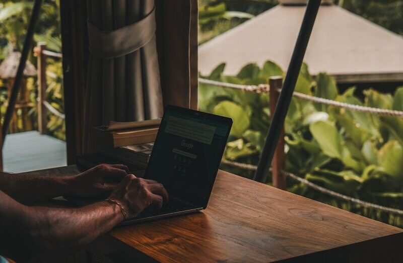 A man sitting at a table using a laptop computer