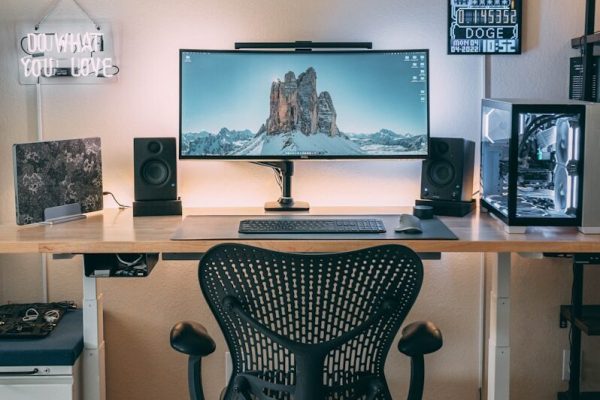 a desk with a computer and speakers on it