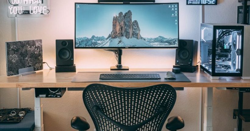a desk with a computer and speakers on it