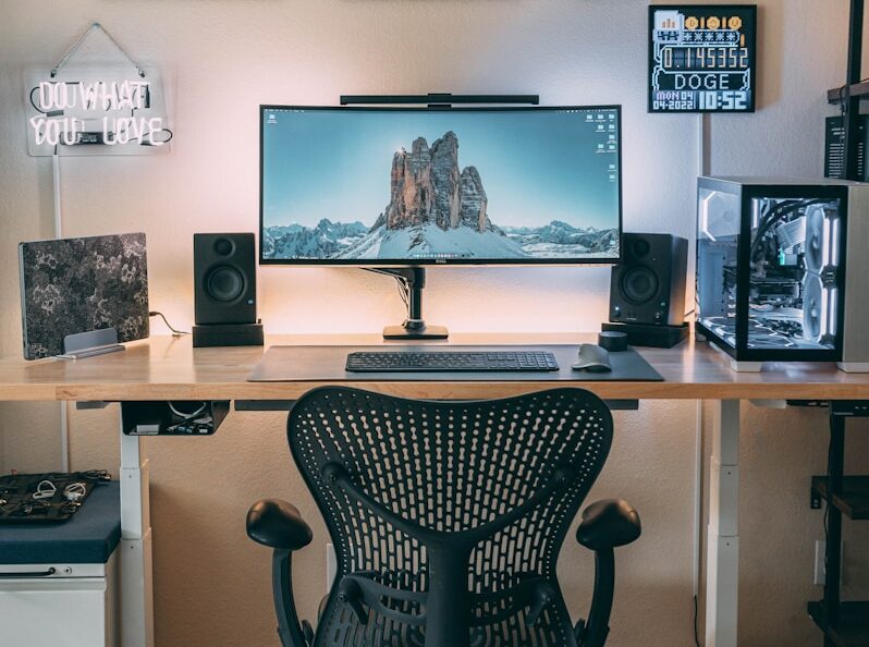 a desk with a computer and speakers on it