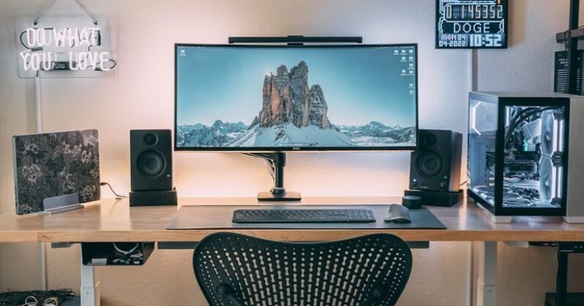 a desk with a computer and speakers on it