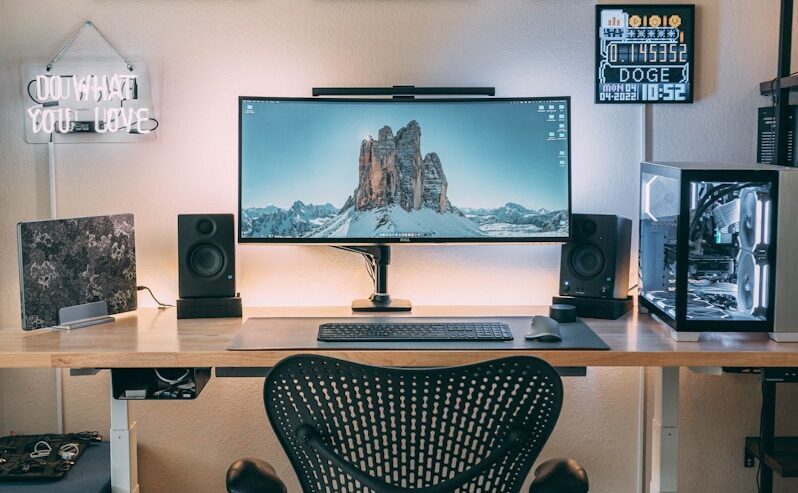 a desk with a computer and speakers on it