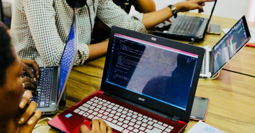 person using black and red Acer laptop computer on table