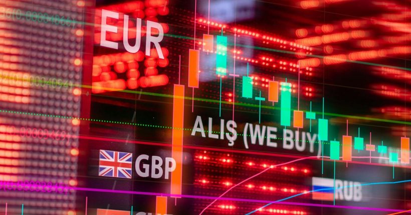 Dynamic forex trading concept with currency symbols and candlestick chart illuminated on screen.