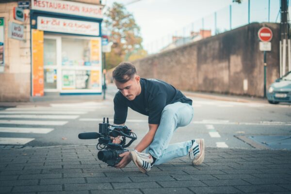 Man filming with a professional camera on the street