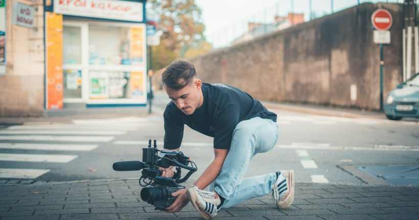 Man filming with a professional camera on the street