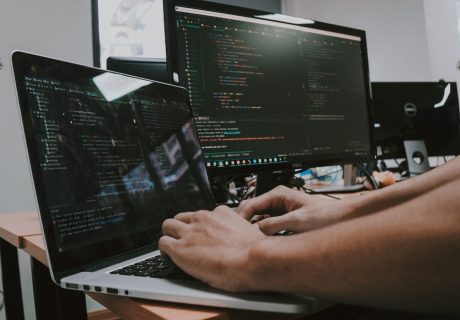 a person typing on a laptop computer on a desk