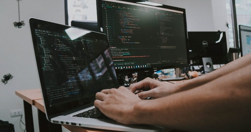 a person typing on a laptop computer on a desk