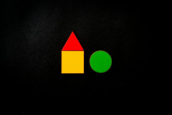 Colorful geometric shapes including a red triangle and yellow square on a black background.