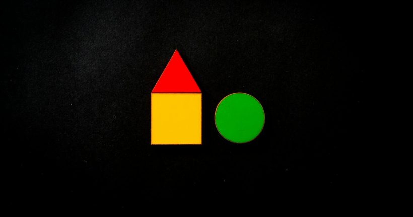 Colorful geometric shapes including a red triangle and yellow square on a black background.