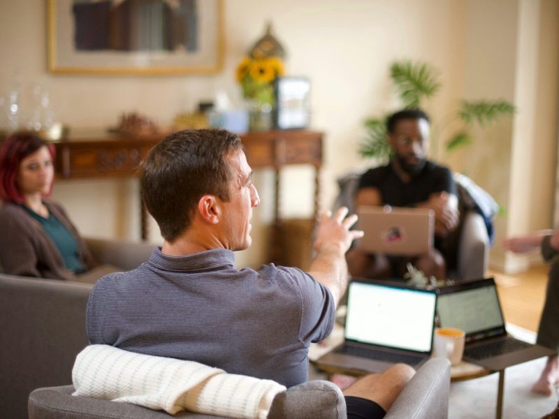 man in gray sweater sitting on couch