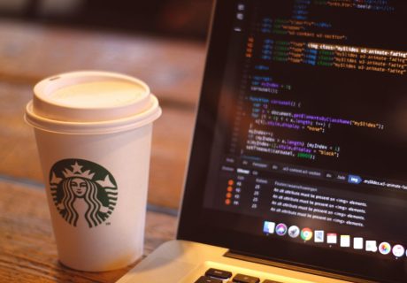 white starbucks cup beside black and silver laptop computer