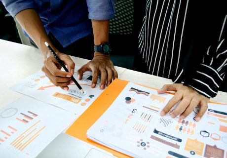 person in blue shirt writing on white paper