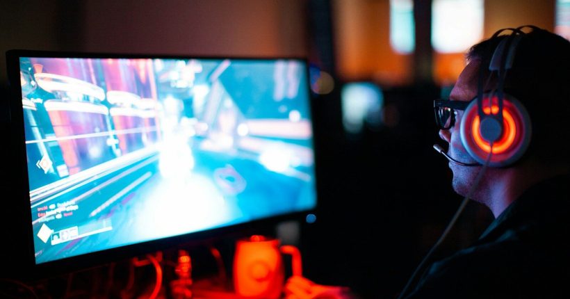 person using computer playing FPS game