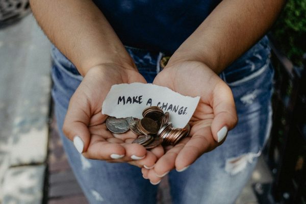 person showing both hands with make a change note and coins