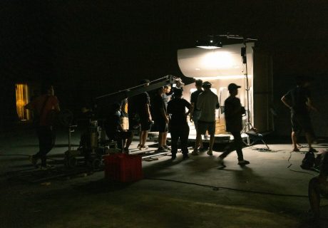 a group of people standing around a camera in the dark
