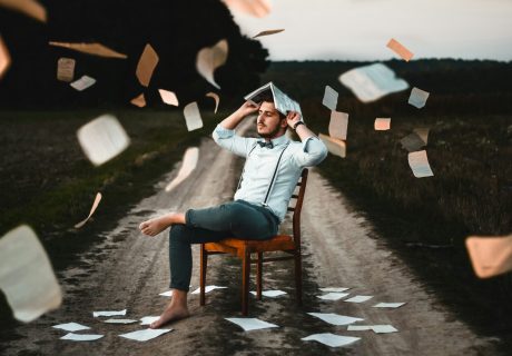 man sitting on chair with book