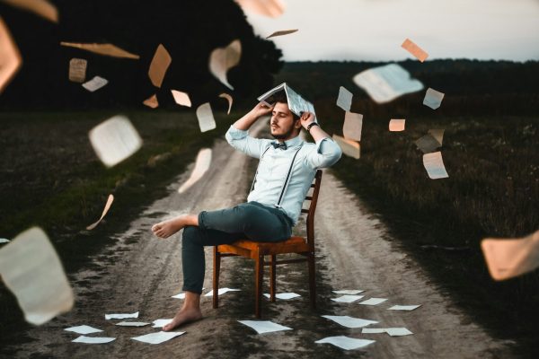 man sitting on chair with book