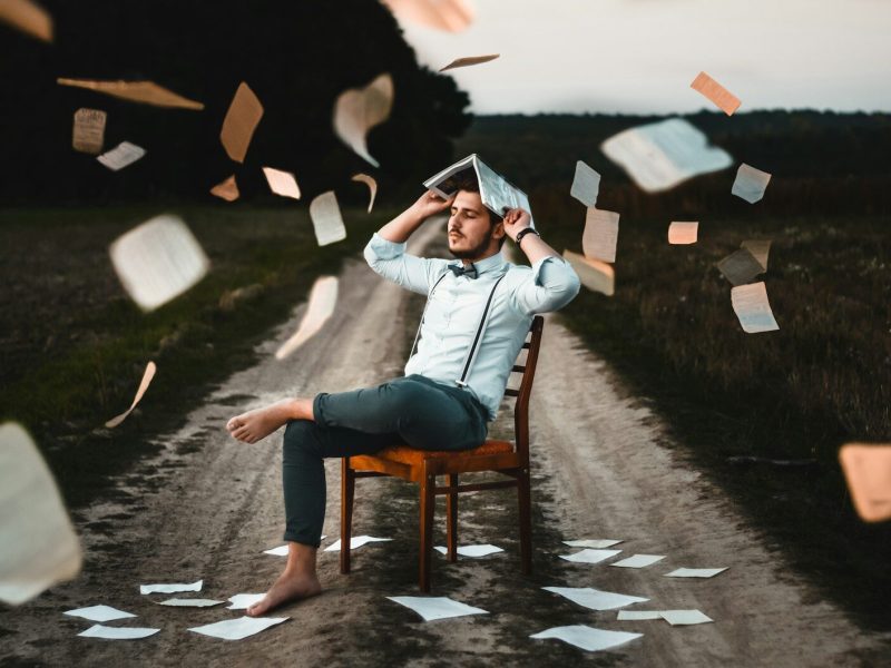 man sitting on chair with book