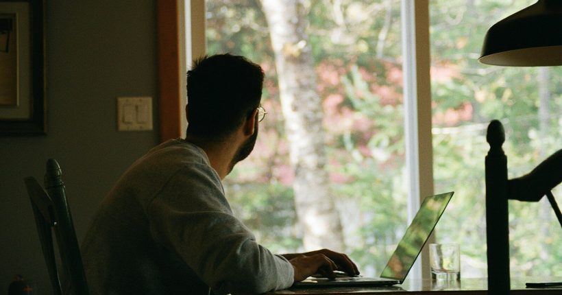man in gray hoodie using laptop computer