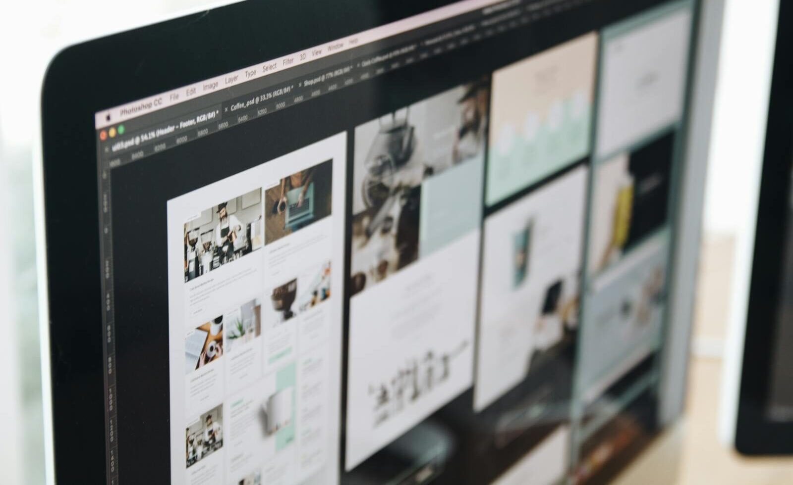 A modern computer screen displaying web design work, showcasing creative visuals in a workspace.