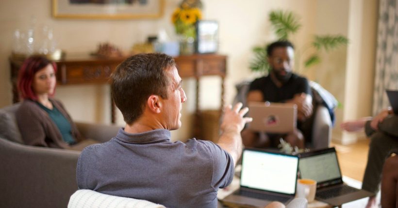 man in gray sweater sitting on couch