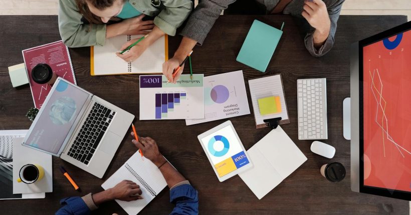 Overhead view of a diverse team collaborating on a project in a modern office setting.