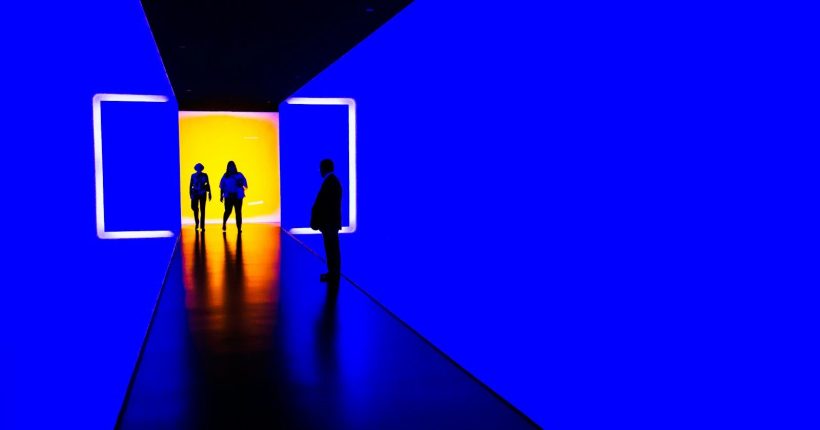 three person standing near wall inside building