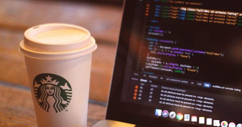 white starbucks cup beside black and silver laptop computer