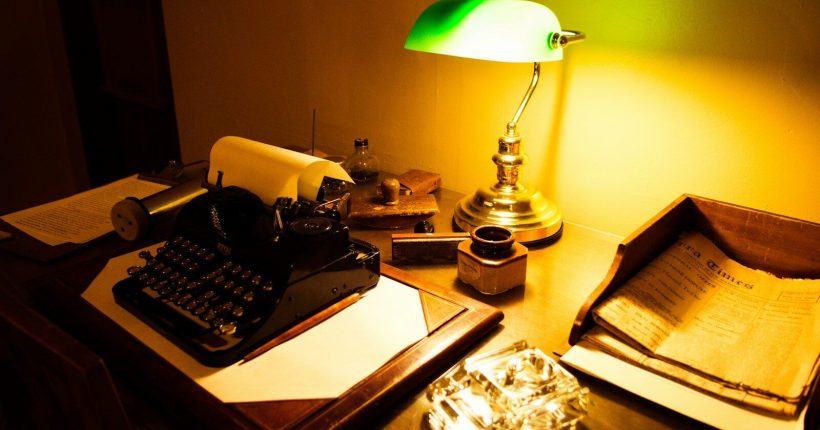 a typewriter and a lamp on a table