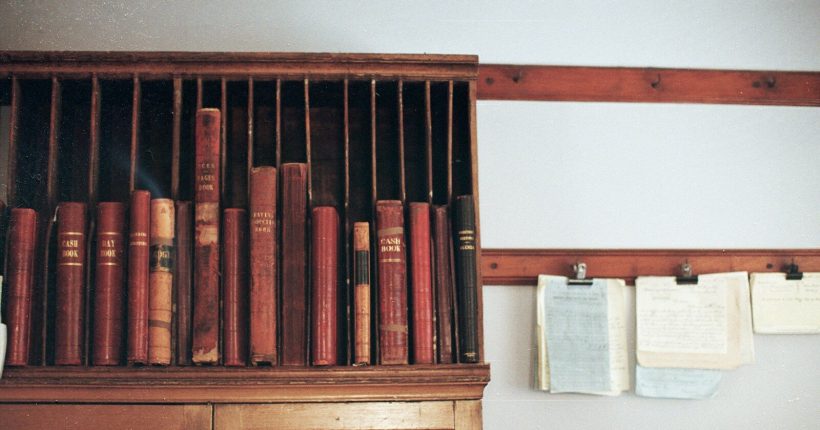 Wooden shelf filled with antique books