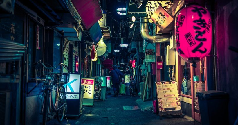black pathway towards city buildings during nighttime
