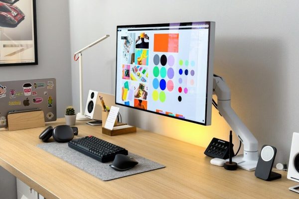 a computer monitor sitting on top of a wooden desk