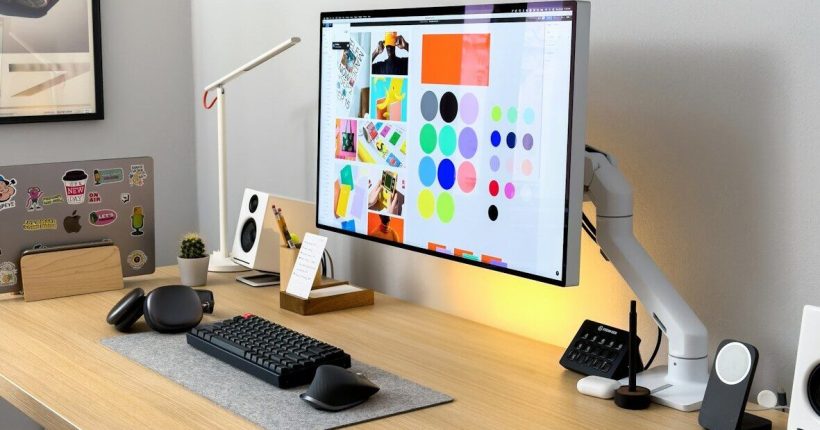 a computer monitor sitting on top of a wooden desk