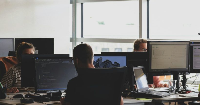 people sitting on chair in front of computer monitor