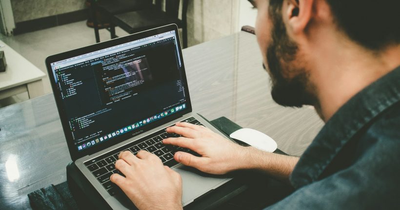 man programming using laptop