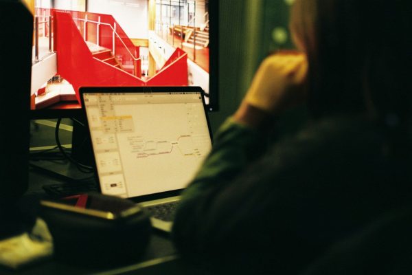 person wearing black jacket in front of flat screen computer monitor